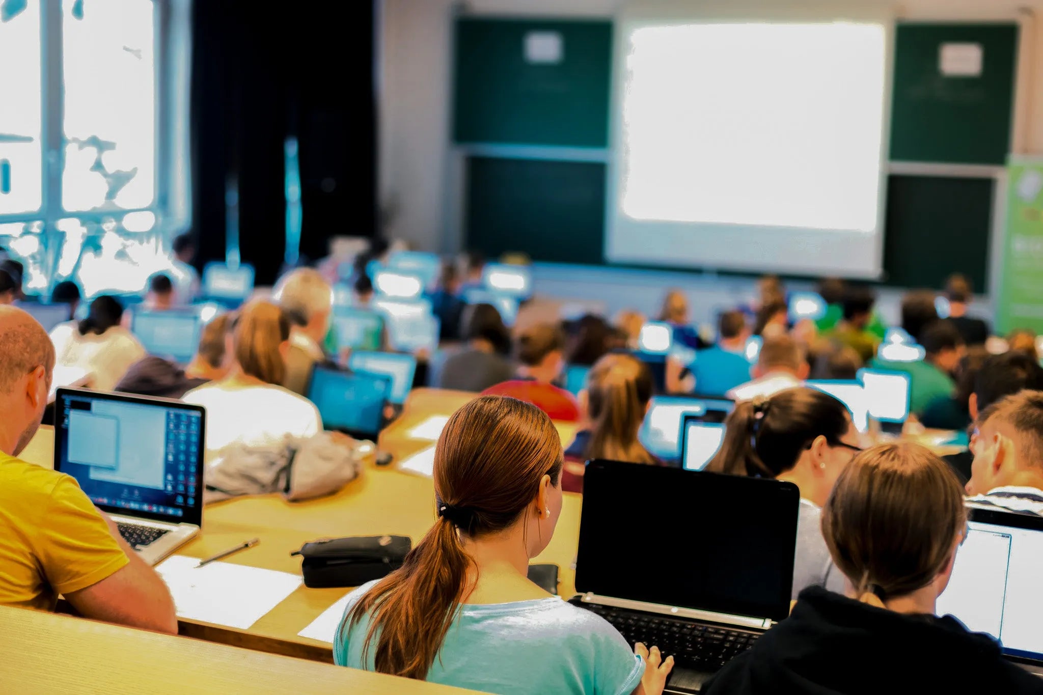 Students in classroom using laptops for learning, education, and training sessions