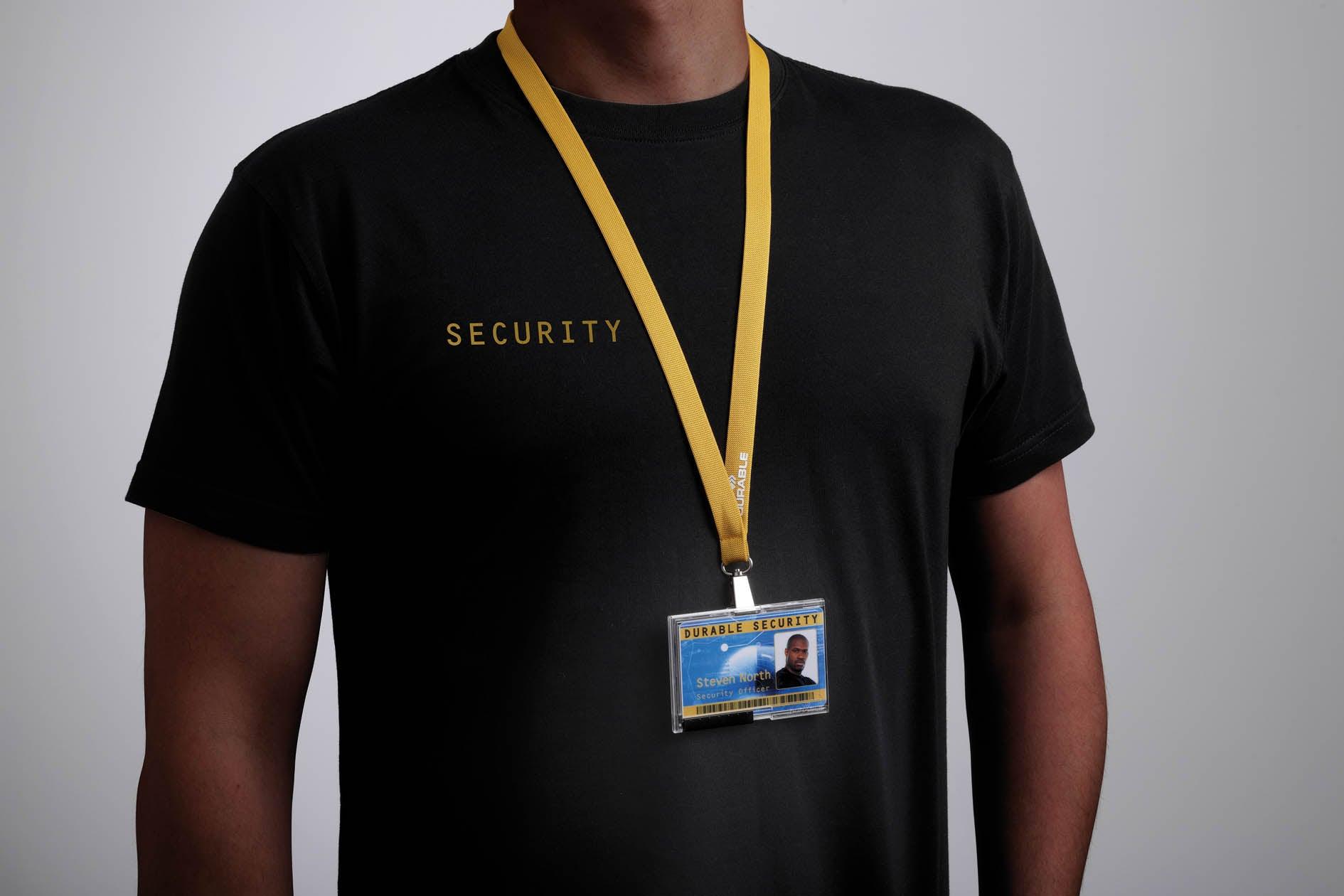Security officer wearing black shirt with yellow lanyard and ID badge for office access