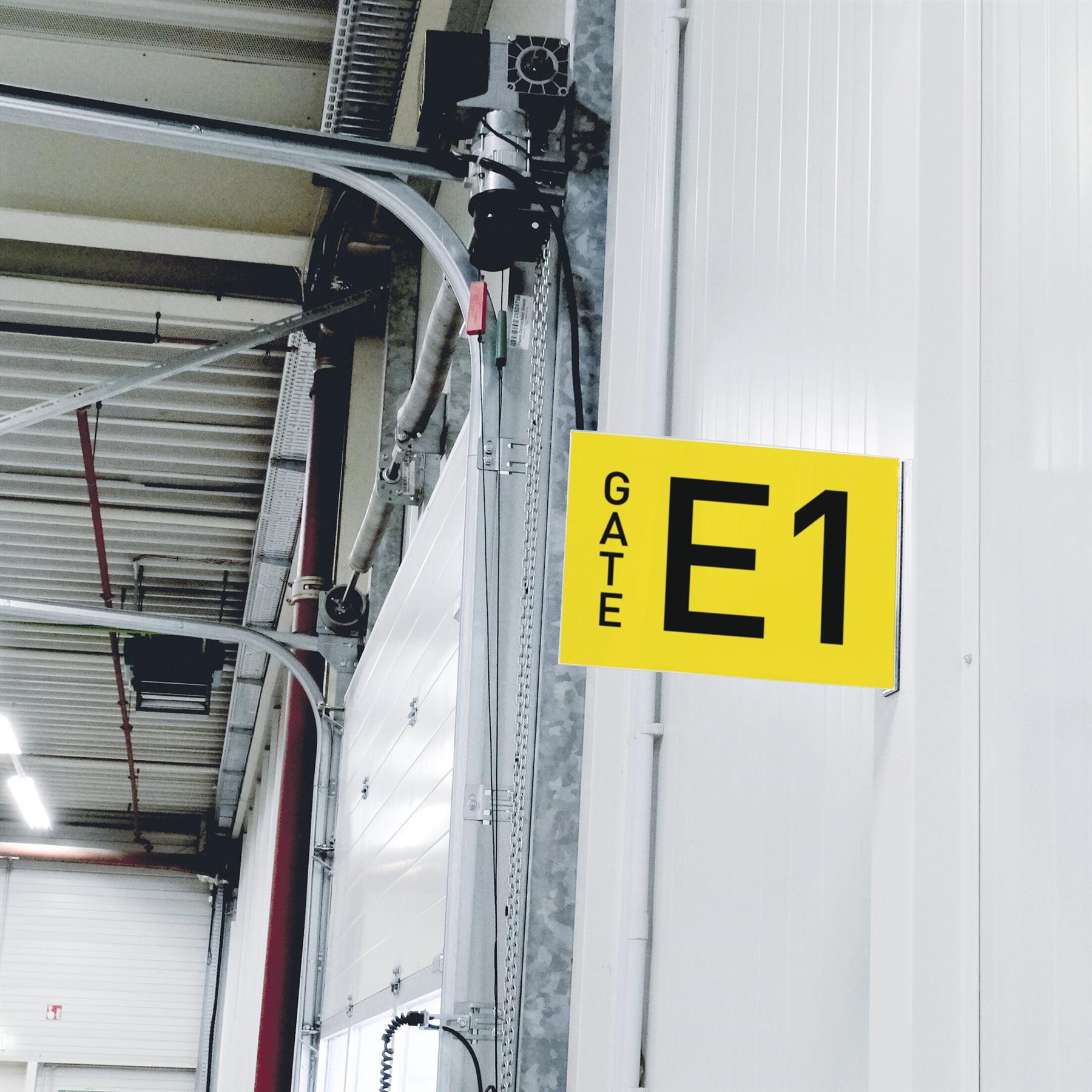 Yellow Gate E1 sign in warehouse loading dock area